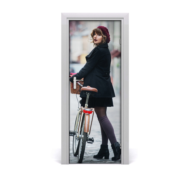 Autocolant de uşă Femeie în beretă cu o bicicletă