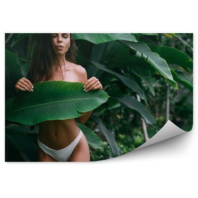 Fototapet Femeie brunetă acoperită cu o natură cu frunze mari
